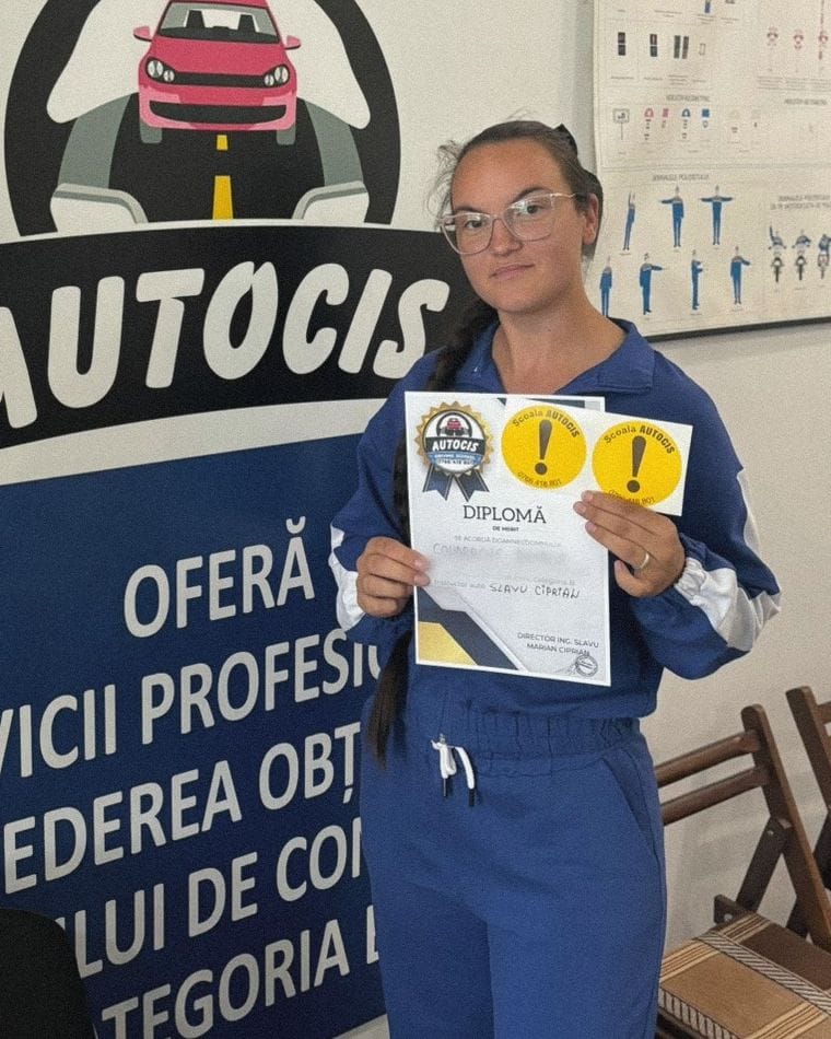 Absolventă a Școlii de șoferi Autocis cu diploma de merit, în fața bannerului Școlii de șoferi Autocis din sediu