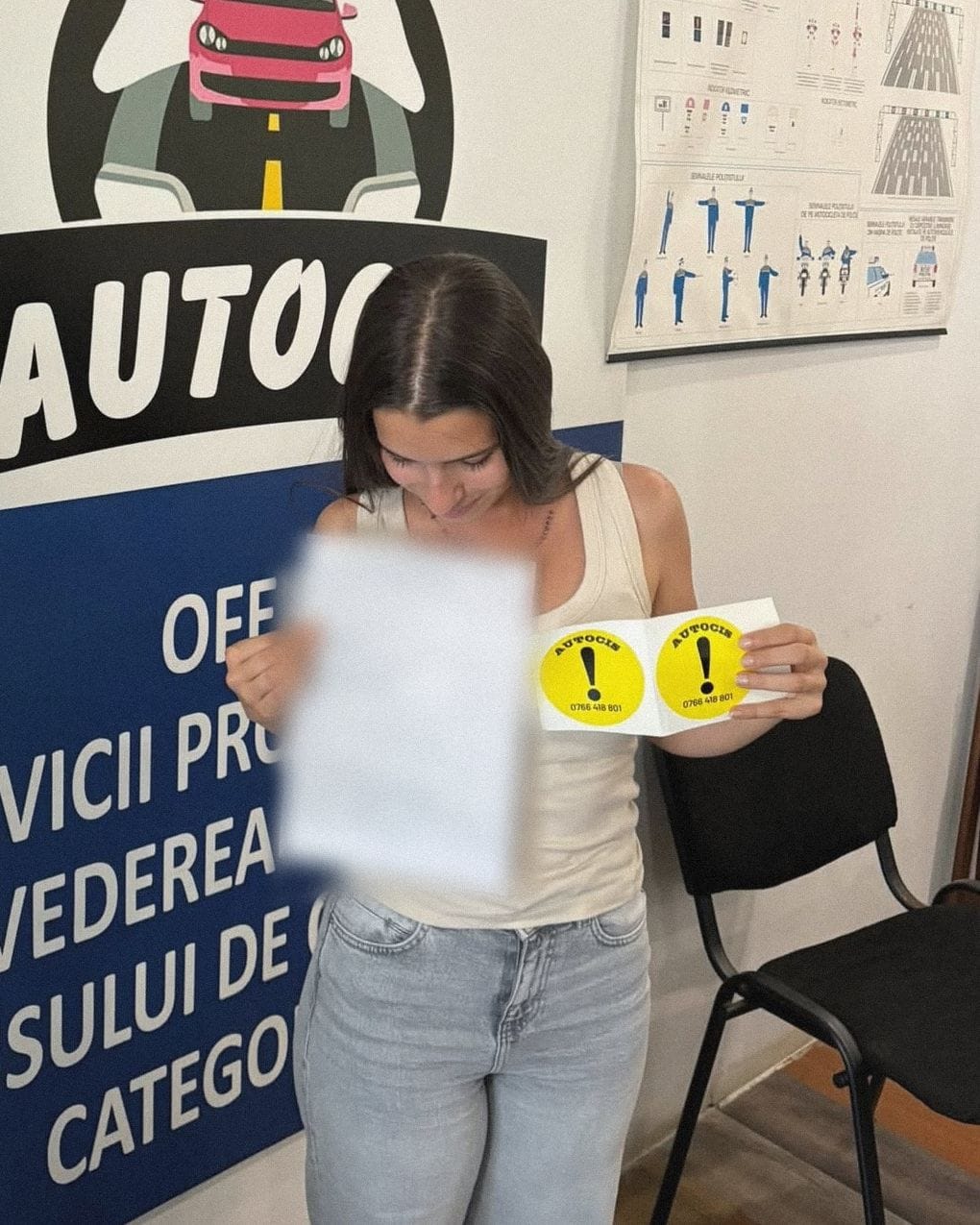 Absolventă a Școlii de șoferi Autocis care își privește actele de la examen, cu semnele de începător în mână, în sediul școlii